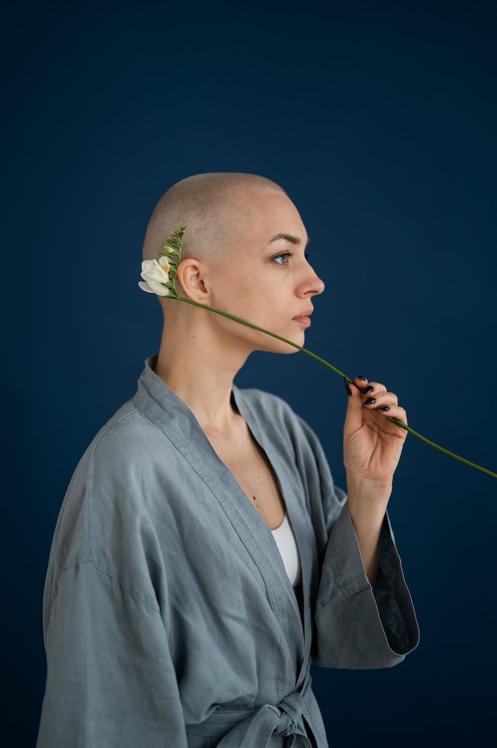a bald woman with a flower