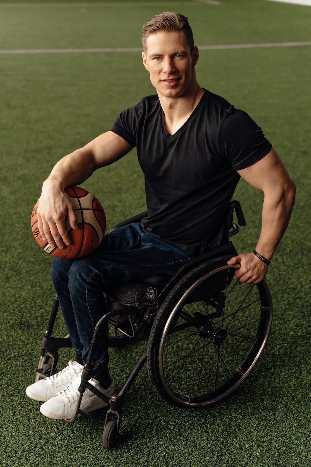 man holding ball in wheelchair on grass