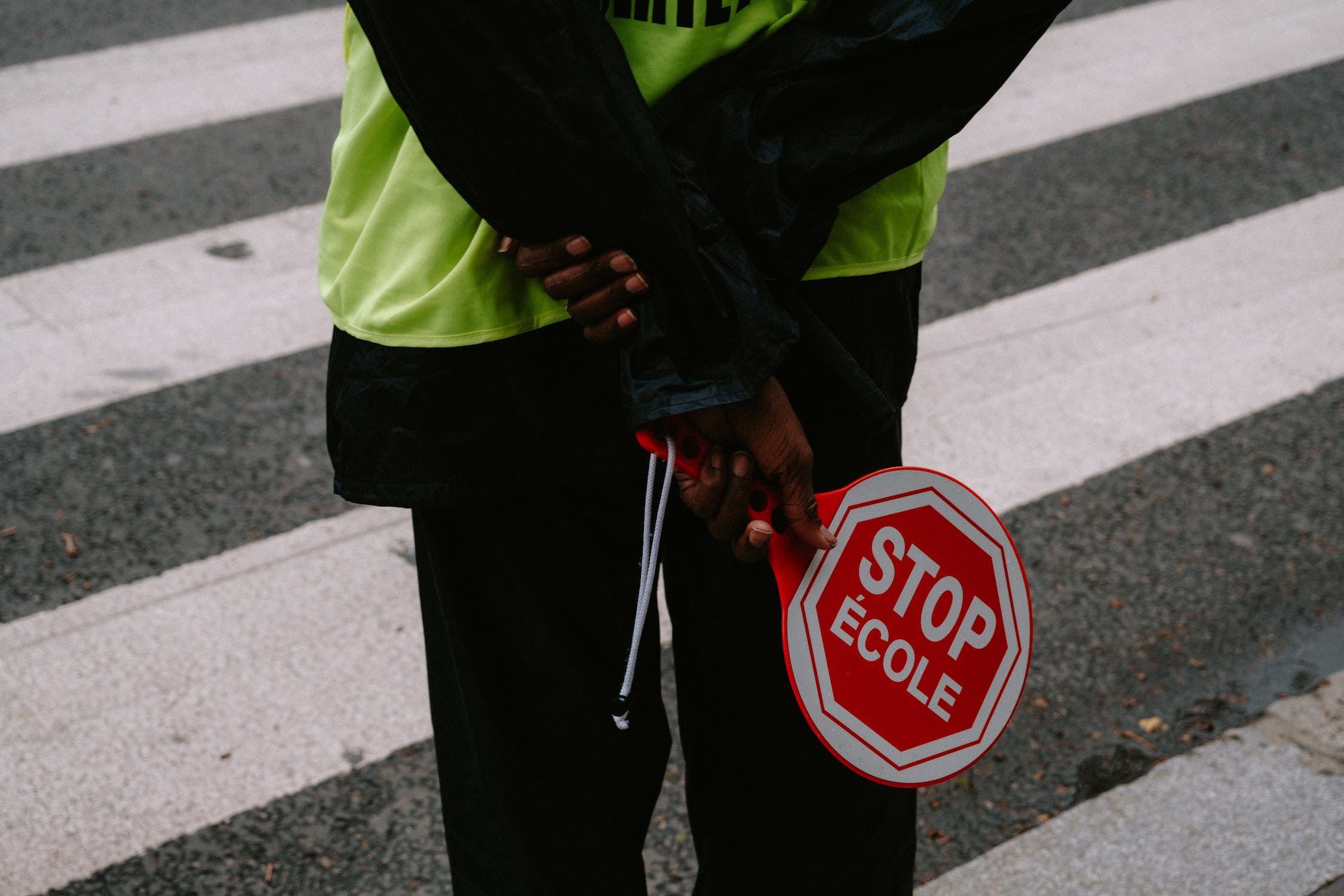 back of a crossing guard on the crosswalk holding stop sign